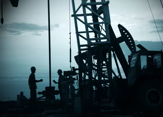 American Oil Pump and workers at dusk