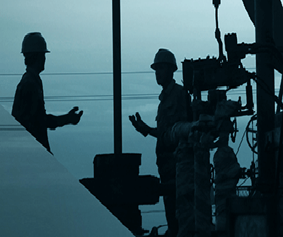 Two industrial workers talking animatedly about maintenance works
