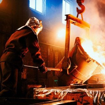 Worker manufacturing product in low light with fire